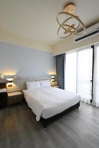 台南的住宿－台南安平 - 理蓄豪宅 - 可加價Ktv及烤肉，卧室配有一张白色大床和吊灯。