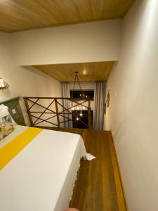1 dormitorio con 1 cama y suelo de madera en Casa aluguel Abraão, Vista Mar, en Abraão