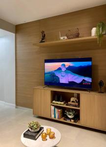 a living room with a flat screen tv on a wooden wall at Apartment Ipanema Arpoador - 300m da praia in Rio de Janeiro