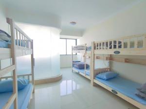 a room with three bunk beds with blue pillows at 都市小憩青旅 in Shenzhen