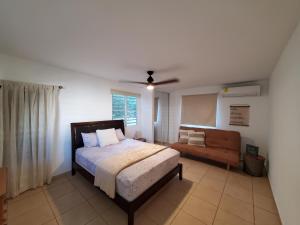 1 dormitorio con 1 cama y 1 sofá en Aguadilla Waves Apt with electricity water AC WIFI 8 minute walk from Crashboat beach en Aguadilla