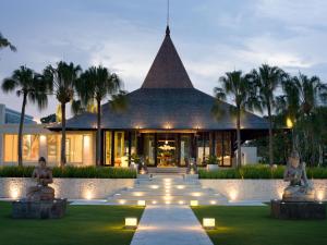 a building with palm trees in front of it at The Royal Santrian in Nusa Dua