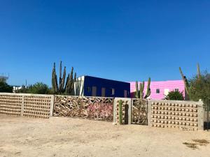una cerca frente a una casa con cactus en Susu’Z Village Hostel and Rooms, en La Ventana