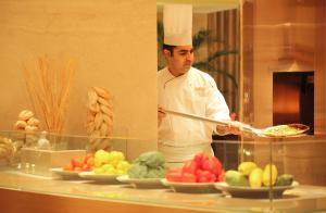 a chef preparing food in a kitchen at Trident Bandra Kurla in Mumbai