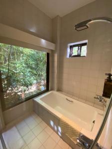 ein Bad mit einer Badewanne und einem Fenster in der Unterkunft The fairy land - Lala Mountain in Fuxing