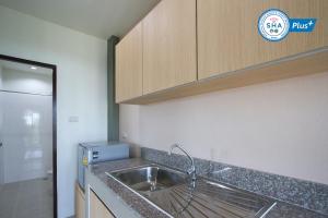 una cucina con un lavello e un piano di lavoro di Sirimunta Hotel Chiang Rai Suite & Residence a Chiang Rai