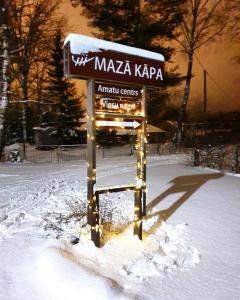 a snow covered park bench in the snow at Mazā Kāpa in Koknese