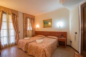 una camera d'albergo con due letti e un tavolo di Albergo Giardino a Sannazzaro deʼ Burgondi