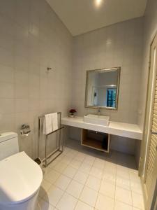 ein Badezimmer mit einem Waschbecken, einem WC und einem Spiegel in der Unterkunft The fairy land - Lala Mountain in Fuxing