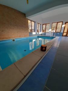uma piscina com água azul num edifício em Pensiunea Montan din Bran,sat Simon SPA indoor em Bran