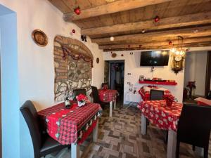 Zimmer mit 2 Tischen und Stühlen sowie einem TV in der Unterkunft NICOLE DONEY LOCAZIONE TURISTICA in Verona