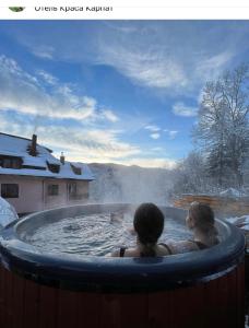 Dos chicas nadando en un jacuzzi en la nieve en Краса карпат, en Yaremche