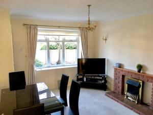 a living room with a dining table and a fireplace at Elite Accomm Wolverhampton sleeps 4 long term workers or family comfortably in Shareshill