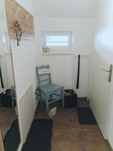 a small room with a blue chair and a window at Ferienwohnung Cooldog Kuschelnest in Imst