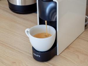 a coffee maker is making a cup of coffee at Cozy Studio with NETFLIX - Apartmanovy dom Bernard in Nový Smokovec