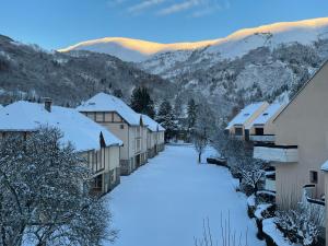 a village covered in snow with mountains in the background at L'appart de Saint-Lary in Saint-Lary-Soulan