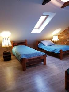a bedroom with two beds and two lamps in it at Agroturystyka Natura in Pilchowice