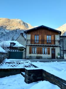 una casa con nieve delante en Maison des trois ormeaux, en Cier-de-Luchon