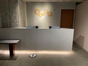 a lobby with a counter and a table and a bench at AMANEK Inn Beppu in Beppu