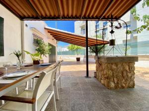 einen Essbereich im Freien mit einem Holztisch und Stühlen in der Unterkunft Big Villa with Pool only 100m to AlcudiaBeach in Alcúdia
