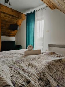 a bedroom with a bed with a stuffed animal on it at Gniewnik in Białka Tatrzańska