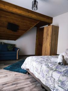 - une chambre avec un lit et un canapé bleu dans l'établissement Gniewnik, à Białka Tatrzańska