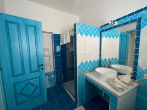 a blue bathroom with a sink and a mirror at Canne al vento in Quartu SantʼElena