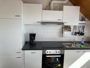 a kitchen with white cabinets and a black counter top at Sophie in Ueckermünde