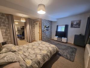 a bedroom with a bed and a flat screen tv at Two Bedroom Barn Conversion in Newquay