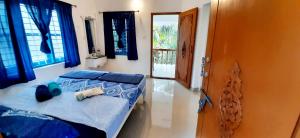 a bedroom with a bed with blue sheets and a window at BLUE SOPHY Residency in Varkala