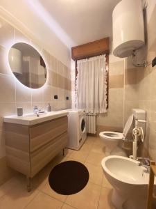W łazience znajduje się umywalka, toaleta i lustro. w obiekcie Maison Claudio CIR VDA-AOSTA- n 0202 w Aoście
