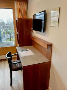 a room with a desk with a tv on a wall at Gasthof Meindl in Lustenau
