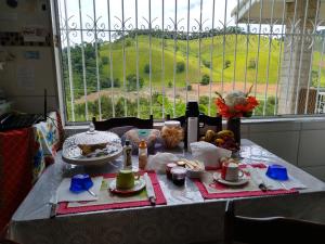 einen Tisch mit Essen drauf mit Aussicht in der Unterkunft Recanto das Videiras in Maria da Fé
