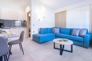 Una sala de estar con un sofá azul y una mesa. en Oli Terra Seaside, en Skala Potamias