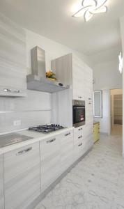 cocina con armarios blancos y fogones en Villa Miami en Bibione