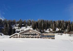 a building on top of a snow covered mountain at AUBERGE DES GLIERES in Thorens-Glières