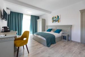 una camera da letto con letto con cuscini blu e scrivania di Volo Guest House a Sub Coastă