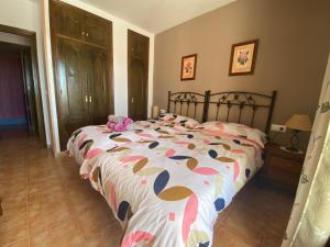 sypialnia z łóżkiem z kolorową kołdrą w obiekcie Bonito apartamento Piscina Wifi w mieście Frigiliana +15 zdjęć