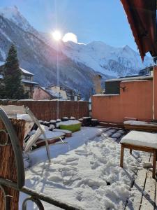 a snow covered patio with the sun shining on the mountains at Chamonix Hyper centre . terrasse vue mont blanc . parking in Chamonix