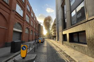 an empty city street with cars parked on the road at Be London - Holborn Boutique Residences in London