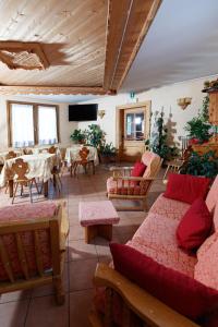 a living room with couches and a table and chairs at Hotel Villa Rina in Bormio