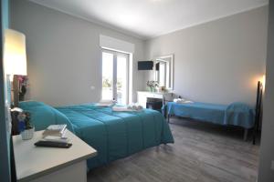 a bedroom with a blue bed and a desk and window at Agriturismo San Raphael in Capaccio-Paestum