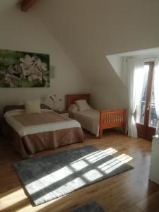 1 dormitorio con 2 camas, ventana y alfombra en Bellevue Josselin en Josselin