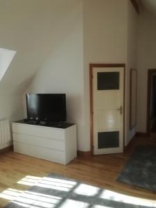 una sala de estar con TV en una cómoda y una puerta en Bellevue Josselin, en Josselin