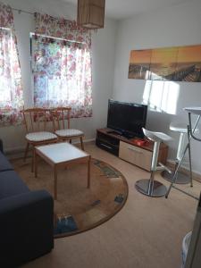 sala de estar con 2 sillas y TV de pantalla plana en Private Wohnung Biop, en Kassel