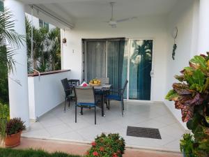 un patio con mesa y sillas. en La Fenice, Playa Popy, en Las Terrenas