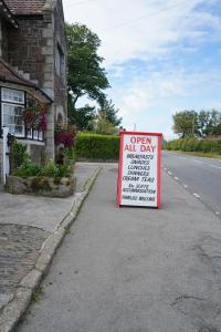 un panneau ouvert toute la journée sur le côté d'une route dans l'établissement Fox & Hounds Hotel, à Lydford