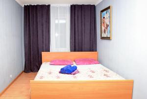 a bedroom with a bed with two pink pillows at Apartment Pushkina in Dnipro