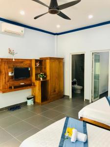a bedroom with two beds and a flat screen tv at BIỂN ĐỒI Bungalow in Phu Quoc