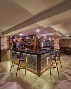 a bar in a restaurant with four bar stools at Asli Makon Hotel in Tashkent